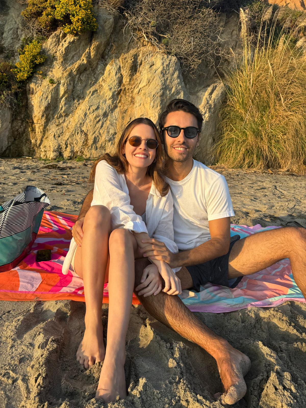 Couple on beach blanket during golden hour